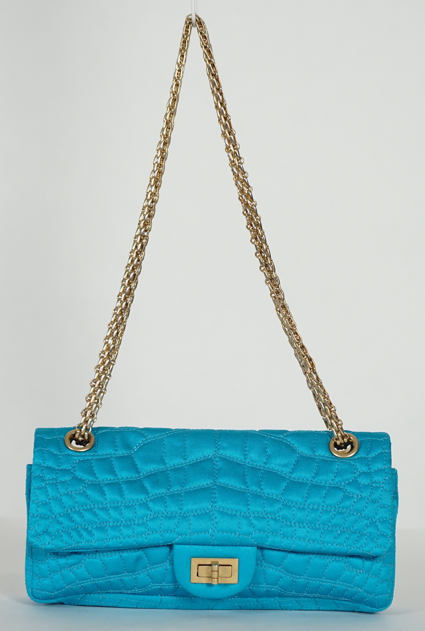 A Chanel medium-sized 2-55 bag in turquoise blue silk satin stitched with a quilted crocodile pattern, width 24cm, height 15cm, depth 6cm, Single handle 112cm, Double handles 65cm